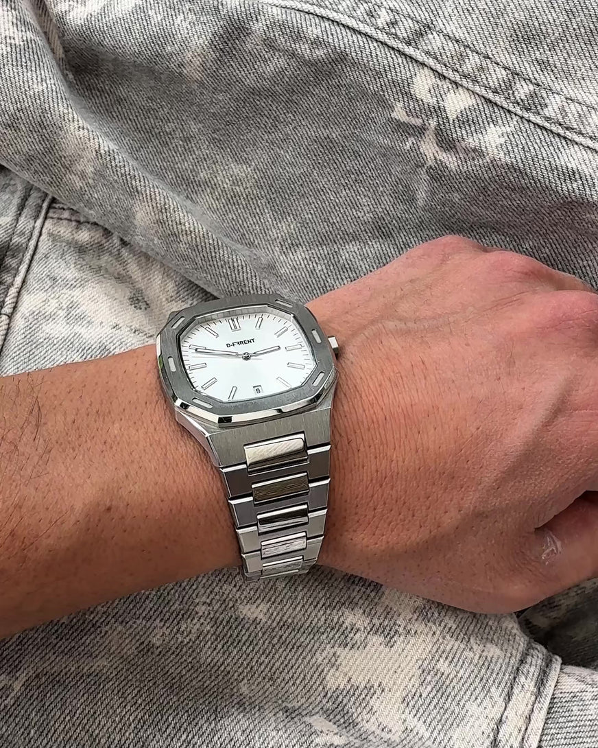 Close-up video of the D-FFRENT The Aura Silver watch on wrist with stainless steel bracelet and silver dial in natural lighting.