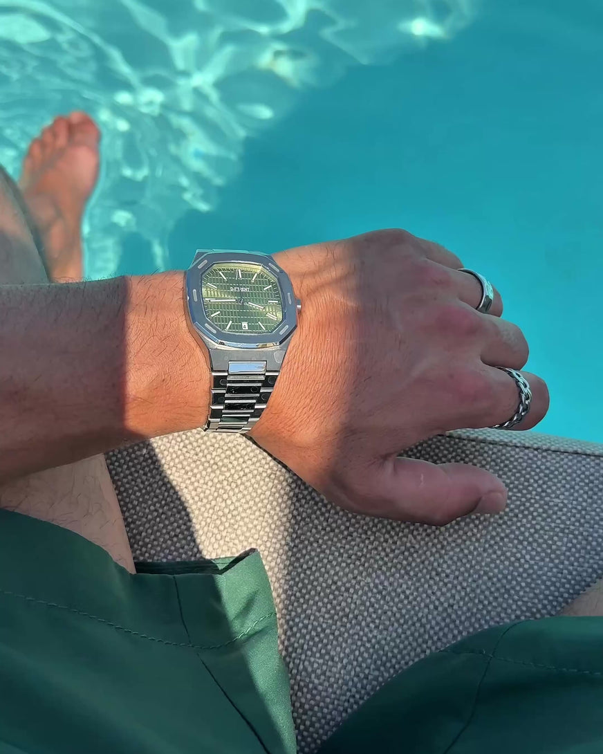 D-FFRENT The Aura Olive Green stainless steel men's watch with olive green dial worn poolside in natural sunlight.