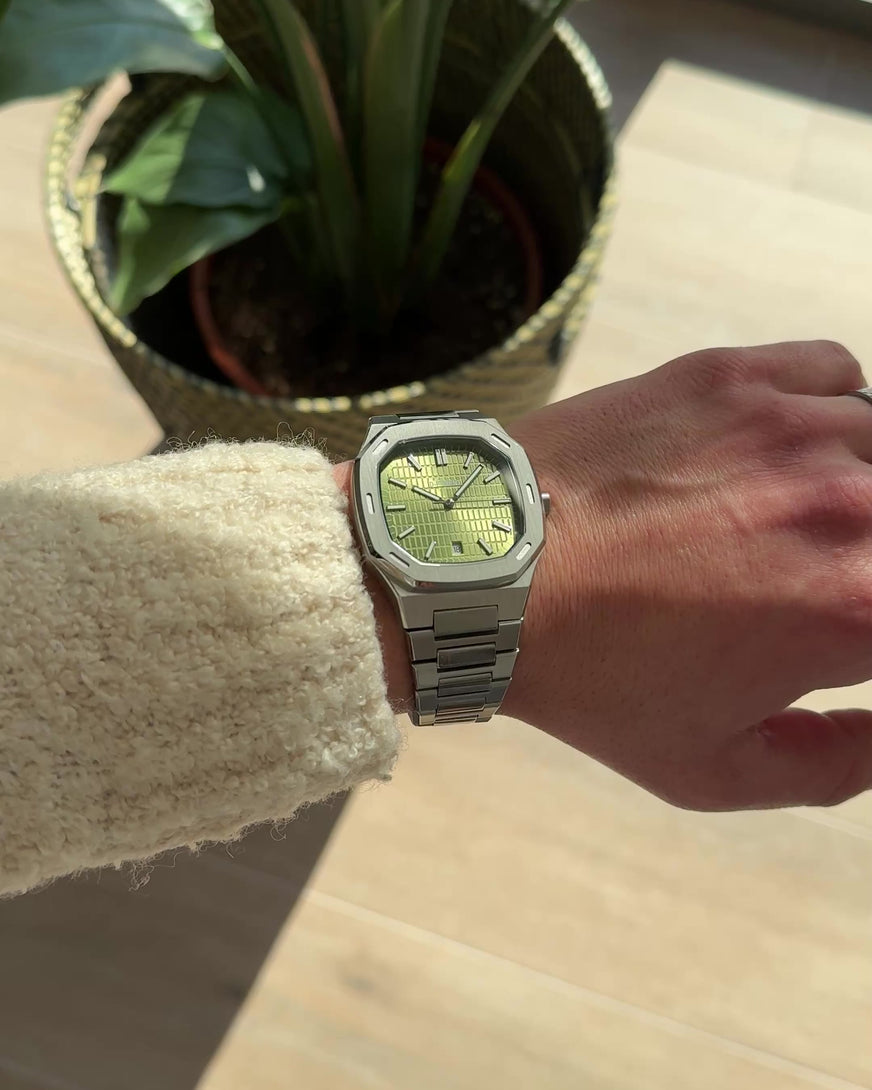 D-FFRENT Aura olive green luxury watch on wrist with rotating movement and blue dial reflection